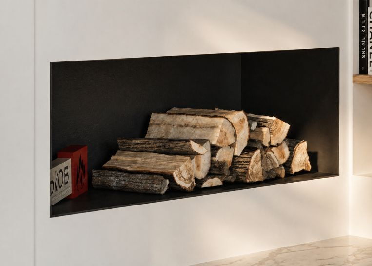 Nahaufnahme einer bündig in die Wand integrierten Holznische mit schwarzer Innenverkleidung, in der gespaltene Holzscheite dekorativ gelagert werden.