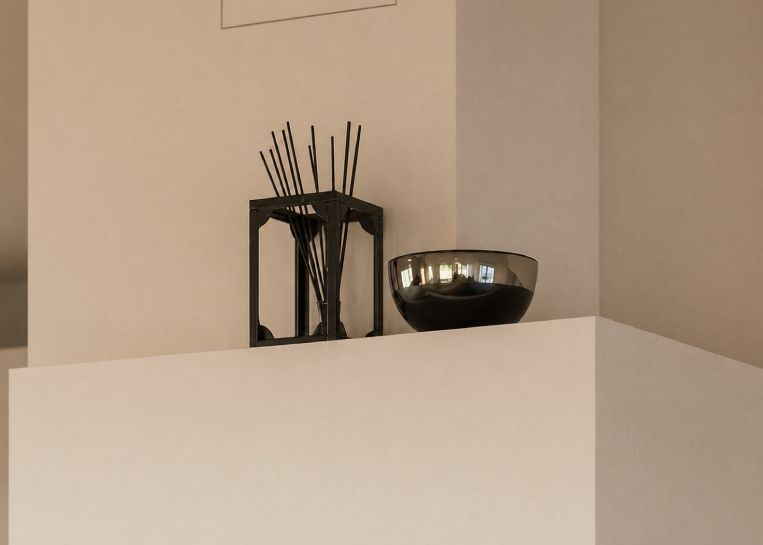 Nahaufnahme der pflegeleichten, mattweißen Keramikabdeckung mit einer stilvollen dunklen Schale und Duftstäbchen als wohnliches Accessoire.