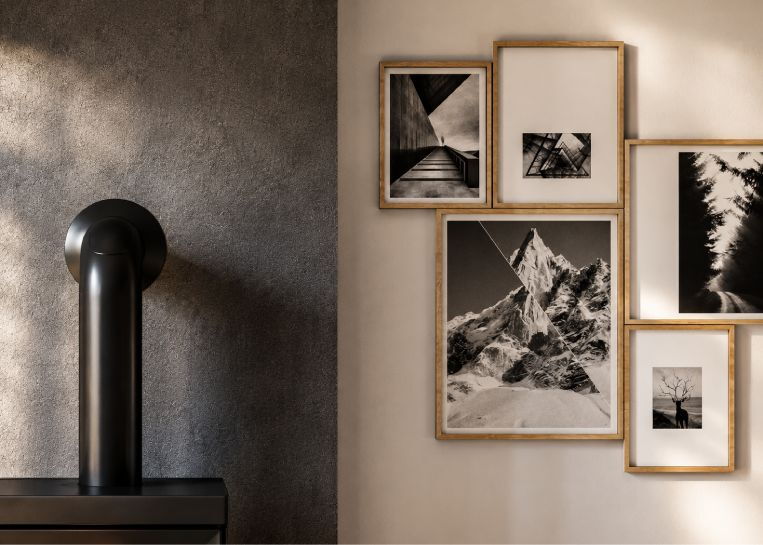 Nahaufnahme der grauen Wandspachtelung mit Fokus auf die glatte Oberfläche und die minimalistischen Bilderrahmen im Holz-Look.