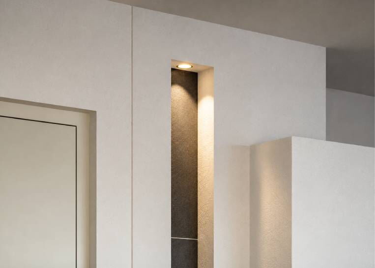 Detaillierte Ansicht der bündig integrierten Lichtnische mit eleganter Keramikverkleidung und Spot-Beleuchtung.
