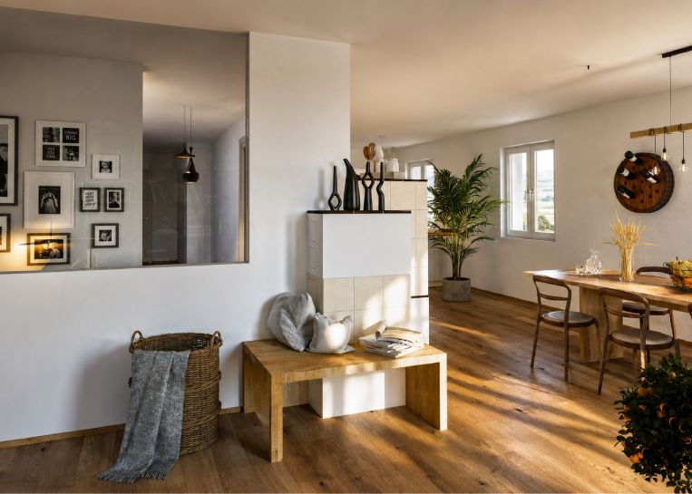 Ansicht vom Wohnzimmer aus auf die Rückseite des Herdes mit einer gemütlichen Sitzbank.
