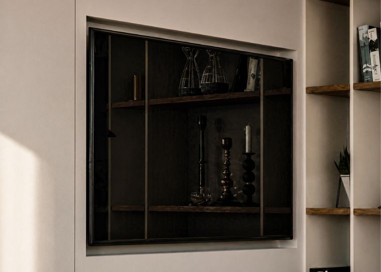 Detailansicht eines flachen Fernsehers, der bündig in die weiße Kaminwand eingelassen ist, um ein minimalistisches Gesamtbild ohne sichtbare Kabel zu schaffen.