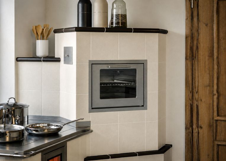 Nahaufnahme des im keramischen Ofenkörper integrierten Backrohrs mit Glasfront für perfekte Garergebnisse durch Speicherwärme.