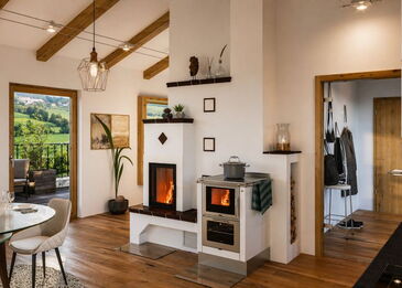 Eine moderne Kaminanlage mit Spartherm Mini Z1 51 Kamineinsatz und integriertem Pertinger Ökoalpin 60 Holzherd in weißem Design.