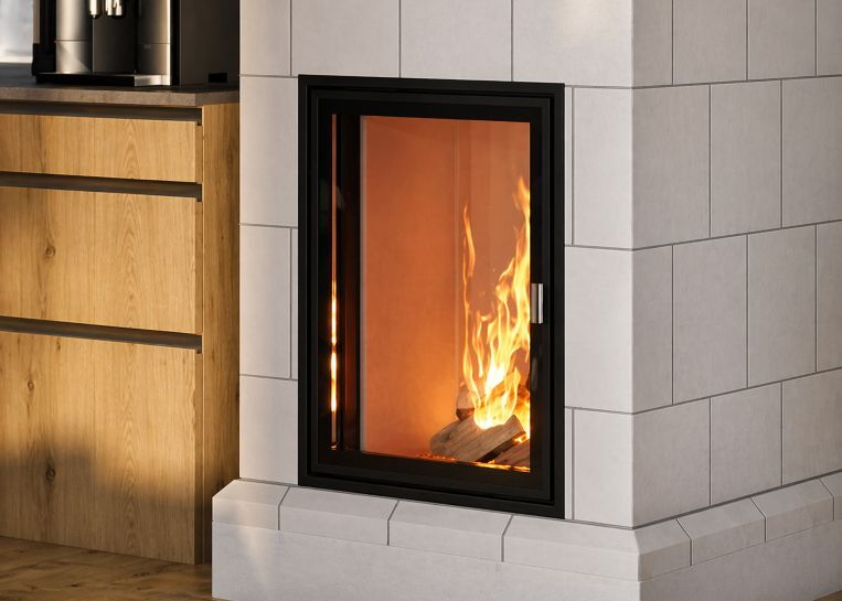 Detailaufnahme eines brennenden Holzfeuers hinter dem schwarzen Sichtfenster eines weißen Kachelofens. Links im Anschnitt eine moderne Holzküche.