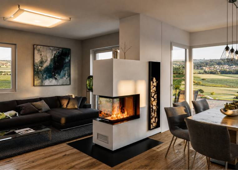Perspektive auf den Kaminbau mit integrierter schwarzer Metallbox für das Holzlager und Blick in den Essbereich.