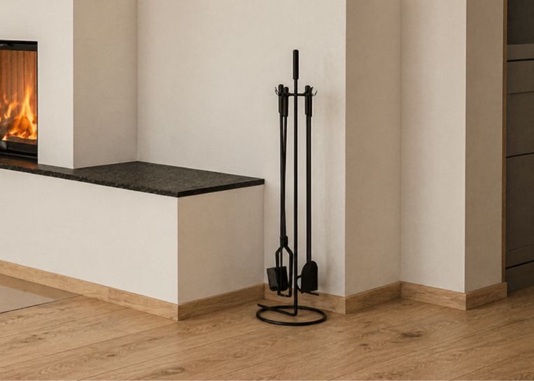 Ein minimalistisches, schwarzes Kaminbesteck-Set steht neben der Sitzbankverlängerung aus edlem Naturstein Nero Assoluto.