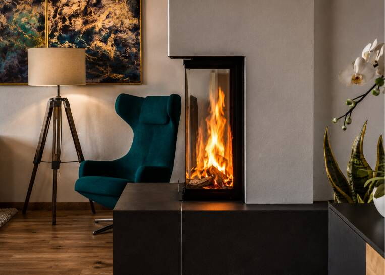 Nahaufnahme der hochgestellten Sichtscheiben mit fesselndem Flammenbild und stilvoller Metallrahmen-Einfassung.