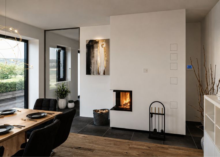Ansicht des brennenden Eckkombiofens, der durch sein minimalistisches Design perfekt mit der modernen Inneneinrichtung harmoniert.