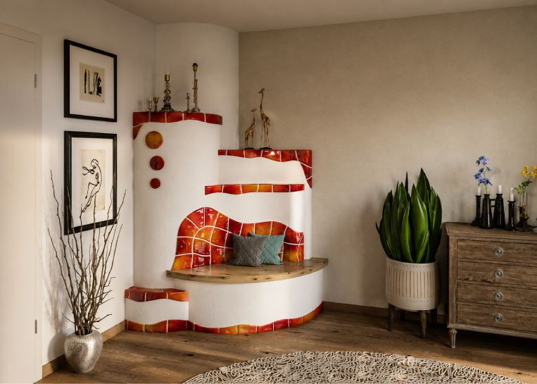 Rückansicht des Herdes als klassischer Kachelofen mit geschwungener Sitzbank und markanter, rot-orange leuchtender Handkeramik.