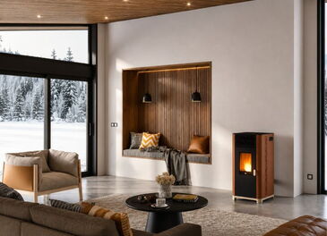 Gesamtansicht des Pelletofens JØTUL PF 1033 in Corten-Ausführung neben einer modernen Holz-Wandnische mit Sitzplatz.